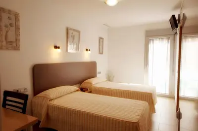 a bedroom with two beds and a table and window at Hostal San Marcos in San Fernando