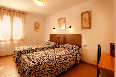 a hotel room with two beds in a bedroom at Hostal San Marcos in San Fernando