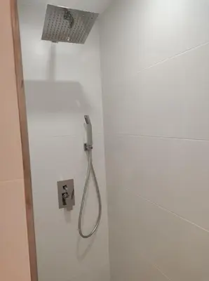 a shower in a white wall with a shower head at Natipao in Rota