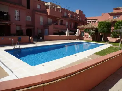 a swimming pool in front of a building at Natipao in Rota