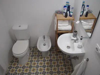 a small bathroom with a toilet and a sink at Casa Valientes B - Parking privado gratis & patio interior in Jerez de la Frontera