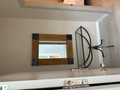 a mirror on a wall above a counter with a metal object at Casa Palacio de Cadiz in Cádiz