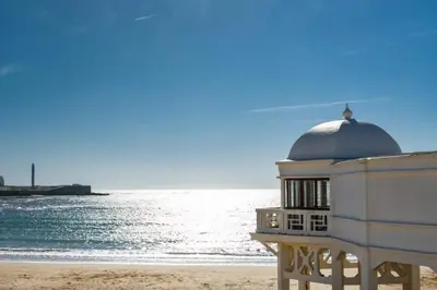 a building on the beach next to the ocean at Casa Palacio de Cadiz in Cádiz