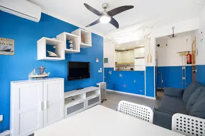 a blue living room with a couch and a tv at El Marinero in Rota