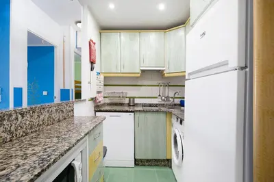 a kitchen with white appliances and a refrigerator at El Marinero in Rota