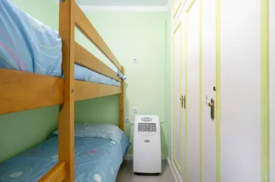 a small bedroom with a bunk bed and a heater at El Marinero in Rota