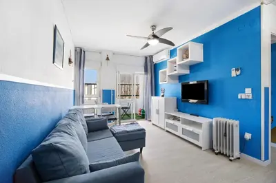 a living room with a couch and a blue wall at El Marinero in Rota