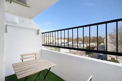 a bench on a balcony with a view of a street at El Marinero in Rota