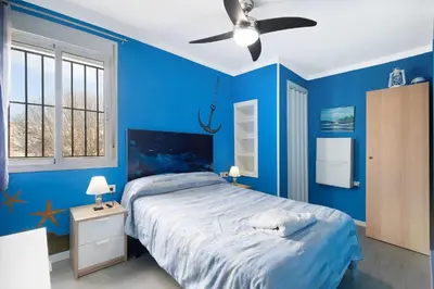 a blue bedroom with a bed and a ceiling fan at El Marinero in Rota
