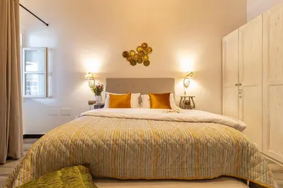a bedroom with a large bed with yellow pillows at Entre Bodegas Jerez in Jerez de la Frontera
