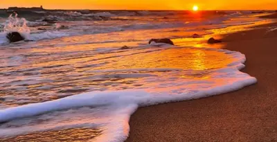 a sunset on the beach with the waves at Precioso Apartamento Jardin del Golf 1, Novo Sancti Petri in Chiclana de la Frontera
