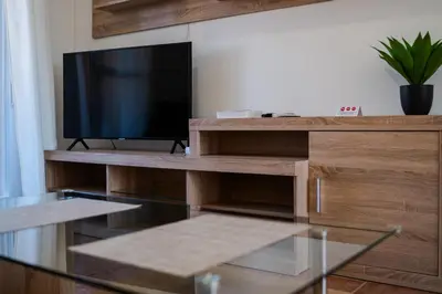 a living room with a television on a wooden entertainment center at Precioso Apartamento Jardin del Golf 1, Novo Sancti Petri in Chiclana de la Frontera
