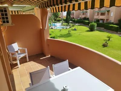 an apartment balcony with a view of a yard at Precioso Apartamento Jardin del Golf 1, Novo Sancti Petri in Chiclana de la Frontera