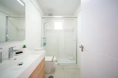 a white bathroom with a shower and a sink at Precioso Apartamento Jardin del Golf 1, Novo Sancti Petri in Chiclana de la Frontera
