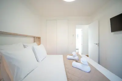 a bedroom with a white bed with blue pillows at Precioso Apartamento Jardin del Golf 1, Novo Sancti Petri in Chiclana de la Frontera