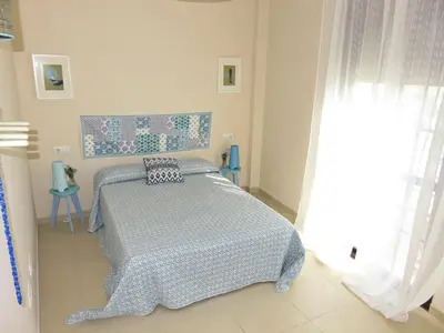 a bedroom with a bed with a blue and white comforter at Apartamento barrio San Miguel in Jerez de la Frontera