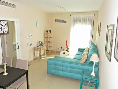 a living room with a blue couch and a table at Apartamento barrio San Miguel in Jerez de la Frontera