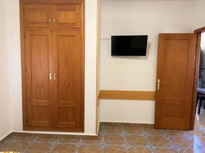 a room with two wooden cabinets and a television at Apartamentos Los Mellizos in Conil de la Frontera