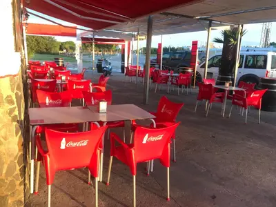 a group of red chairs and tables in a restaurant at Hostal Playa Candor in Rota
