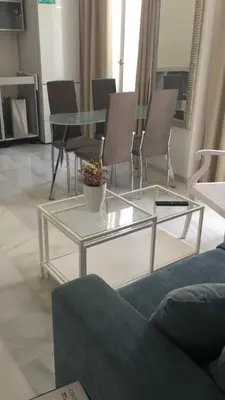 a living room with a glass table and chairs at Apartamento Calle Nueva in Cádiz