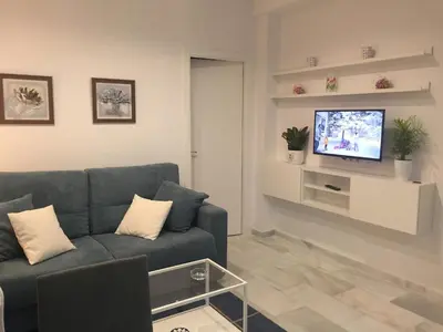 a living room with a blue couch and a tv at Apartamento Calle Nueva in Cádiz