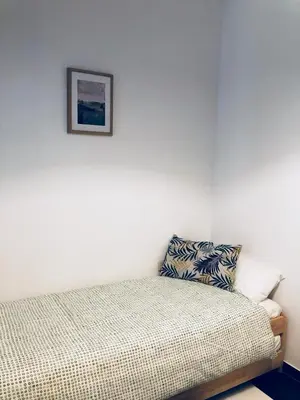 a bedroom with a bed with a picture on the wall at Apartamento San Francisco in Cádiz