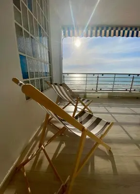 a wooden chair sitting in a room with a window at Life Apartments Fuentebravía in El Puerto de Santa María