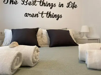 a bedroom with a bed with the words the best things in life arent things at Life Apartments Fuentebravía in El Puerto de Santa María