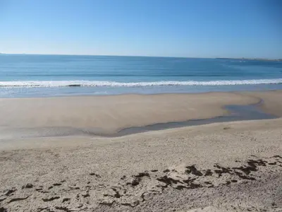 a sandy beach with the ocean in the background at Life Apartments Fuentebravía in El Puerto de Santa María