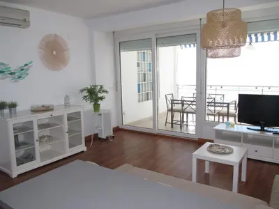 a living room with a large window and a television at Life Apartments Fuentebravía in El Puerto de Santa María