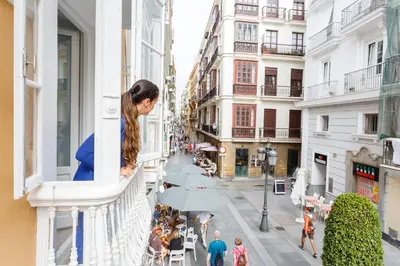 a woman looking out of a window in a city at Nueva ALMUDENA Apartment by Cadiz4Rentals in Cádiz