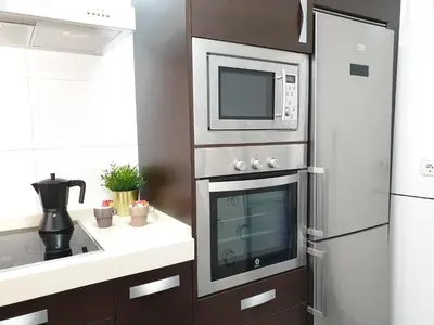a kitchen with a microwave and a refrigerator at Sherryflat Moneo - Parking in Jerez de la Frontera