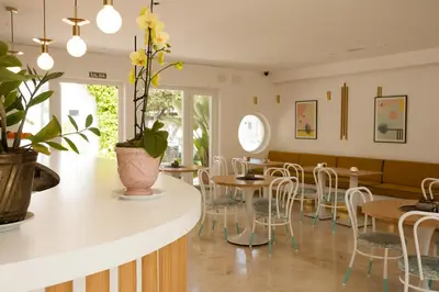 a restaurant with tables and chairs and a counter at Hostal Las Cumbres in Conil de la Frontera