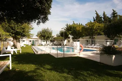 a swimming pool in a yard with a pool at Hostal Las Cumbres in Conil de la Frontera