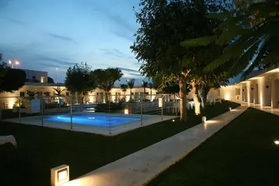 a courtyard with a swimming pool at night at Hostal Las Cumbres in Conil de la Frontera