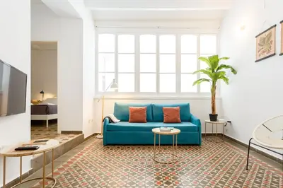 a living room with a blue couch and a window at Tierra & Mar Ascensor Grupo AC Gestion in Cádiz
