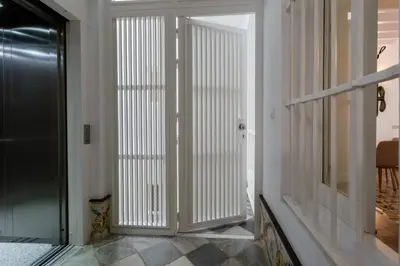 a hallway with white vertical blinds on a door at Tierra & Mar Ascensor Grupo AC Gestion in Cádiz