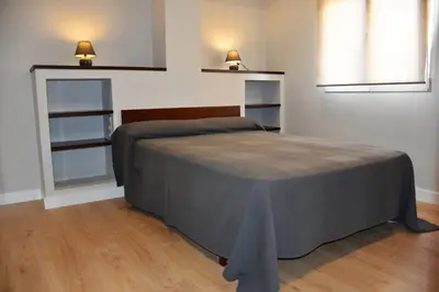 a bedroom with a bed and two lights on the wall at Sweet Velázquez Apto. zona Playa Victoria in Cádiz