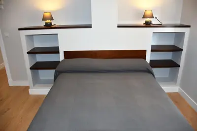 a bed in a room with two lamps on shelves at Sweet Velázquez Apto. zona Playa Victoria in Cádiz