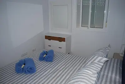 a bedroom with a bed with blue towels on it at Apartamentos Costa de la Luz playa in Rota