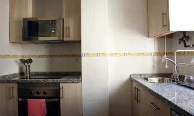 a kitchen with a sink and a microwave at Apartamentos Costa de la Luz playa in Rota
