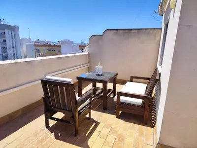 a balcony with a table and chairs on a roof at Apartamentos Costa de la Luz playa in Rota