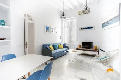 a white living room with a table and a couch at Mar de Cadiz by Cadiz Time in Cádiz