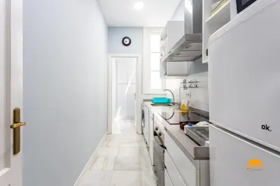 a kitchen with white cabinets and a white floor at Mar de Cadiz by Cadiz Time in Cádiz