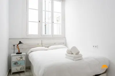 a white bedroom with two beds and a window at Mar de Cadiz by Cadiz Time in Cádiz