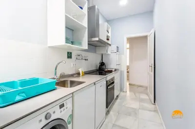 a kitchen with white cabinets and a sink and a dishwasher at Mar de Cadiz by Cadiz Time in Cádiz