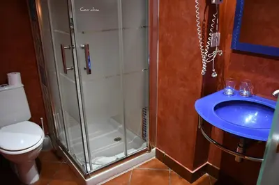 a bathroom with a shower and a toilet and a sink at Hostal El Puerto Boutique in Chipiona