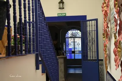 a blue staircase with a blue door in a building at Hostal El Puerto Boutique in Chipiona