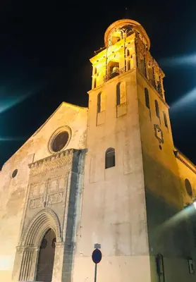 a building with a clock tower at night at Preciosa casa baja con aire acondicionado in Sanlúcar de Barrameda