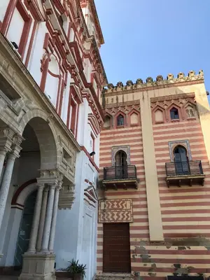 a building with two balconies on the side of it at Preciosa casa baja con aire acondicionado in Sanlúcar de Barrameda